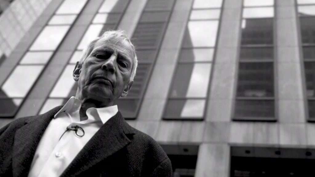 Robert Durst, zdjęcie w czerni i bieli na tle budynku, fotografia wykonana od dołu, Durst patrzy w kamerę; intrygująca pozycja na liście seriali true crime